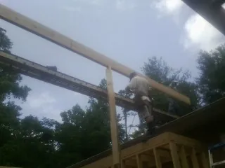 Carpenter setting a ridge beam over a new addition frame — Ice Dam Removal by Roofing Brothers in North Grosvenordale