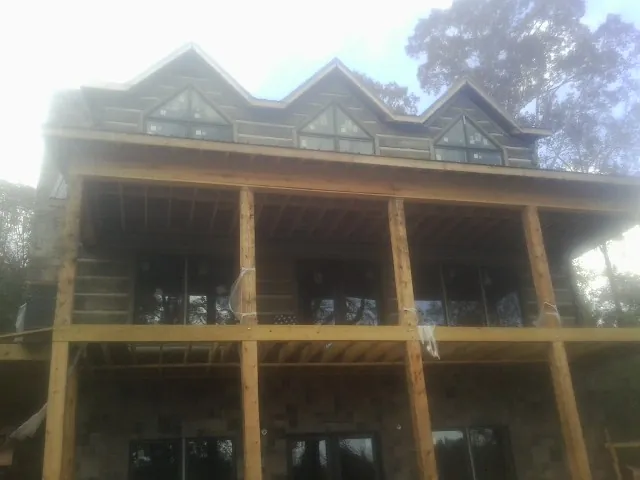 Dormers and porch framing on a large log home under construction — Roof Coating work by our crew in North Grosvenordale