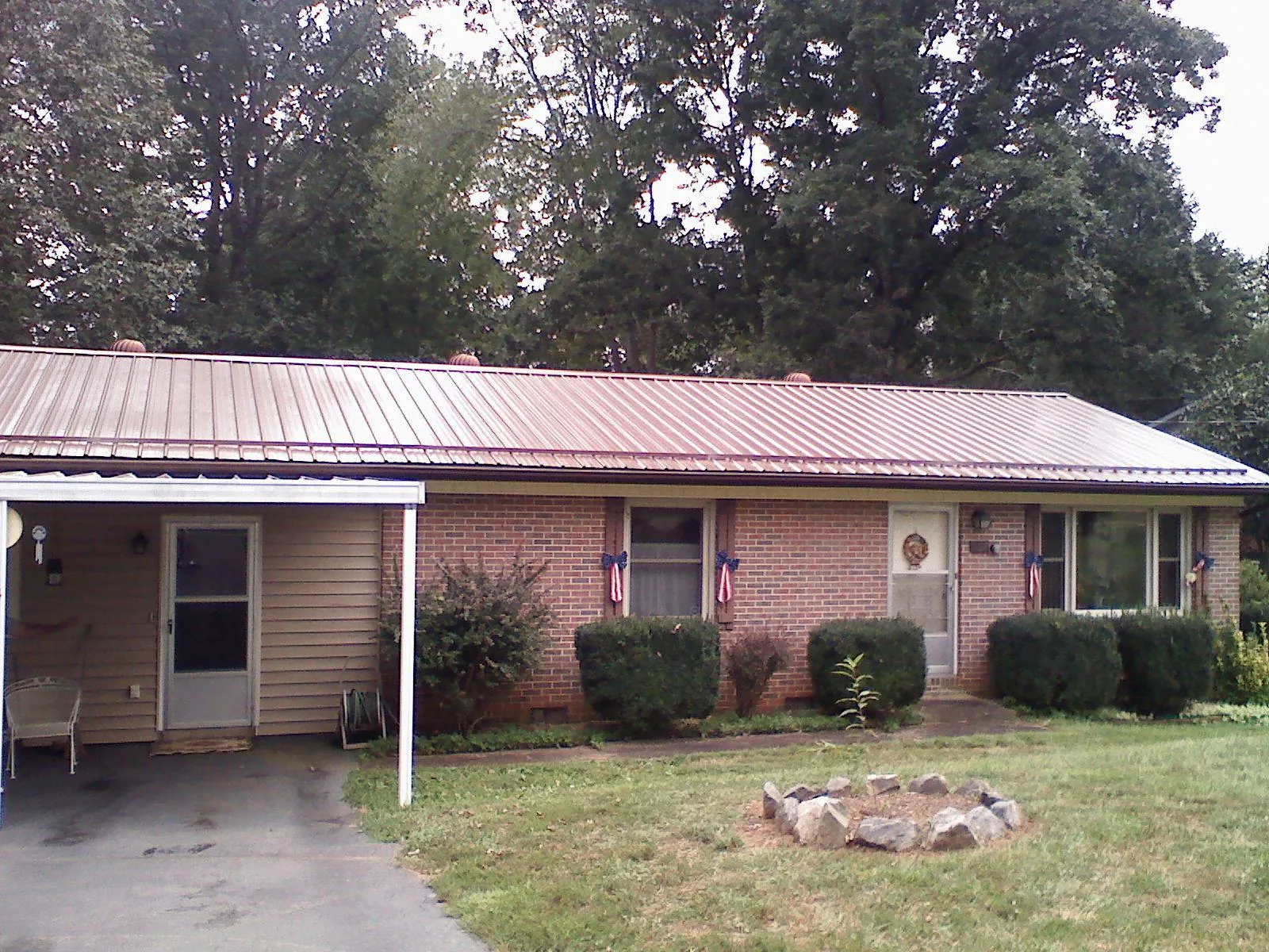 Bronze metal roof and carport on a brick ranch home — Roof Repair work by our crew in North Grosvenordale